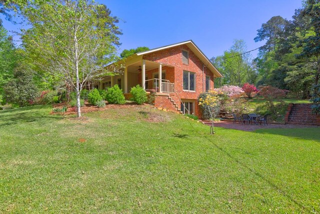 136 Kings Rd, Milledgeville, GA 31061 - back of property featuring a yard, stairs, brick siding, a porch, and a patio