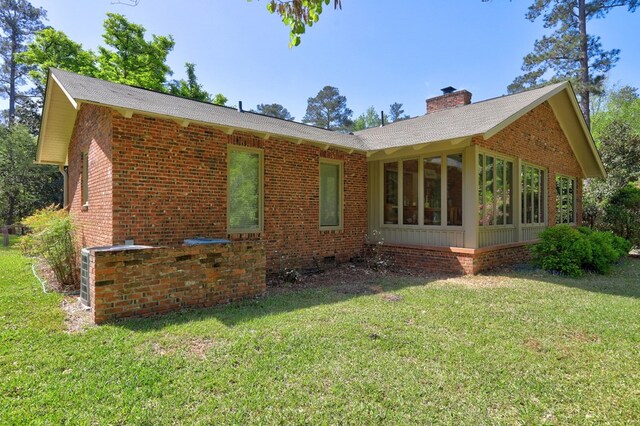 136 Kings Rd, Milledgeville, GA 31061 - back of property featuring a chimney, a sunroom, brick siding, and a yard