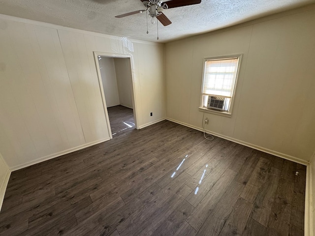 spare room featuring ceiling fan, dark hardwood / wood-style floors, cooling unit, and a textured ceiling