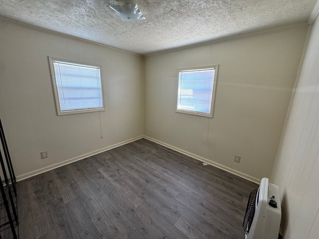 empty room with ornamental molding, dark hardwood / wood-style floors, and a textured ceiling