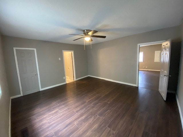 interior space featuring baseboards, dark wood-style floors, and a ceiling fan