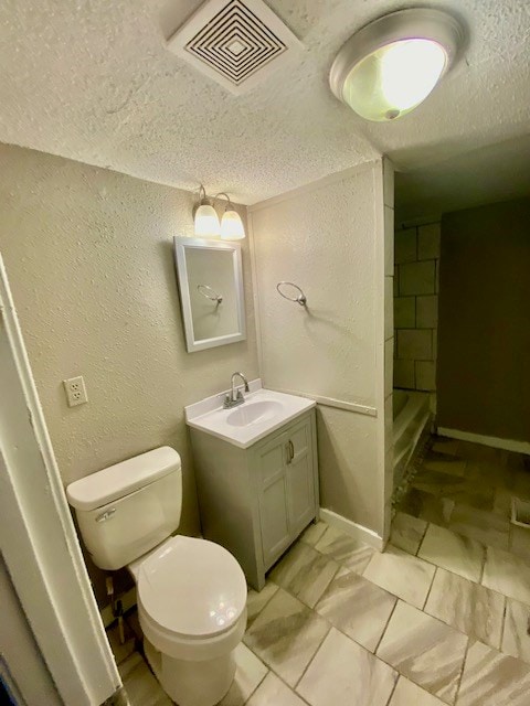 bathroom with visible vents, toilet, a textured wall, a textured ceiling, and a shower