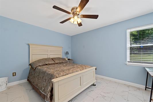 2122 Harbour Point Dr, Sparta, GA 31087 - bedroom with light marble finish flooring, a ceiling fan, and baseboards