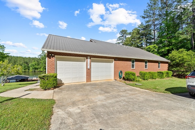 2122 Harbour Point Dr, Sparta, GA 31087 - view of side of home featuring brick siding, concrete driveway, metal roof, an attached garage, and a yard