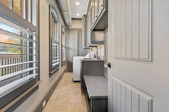 laundry room with cabinets and sink