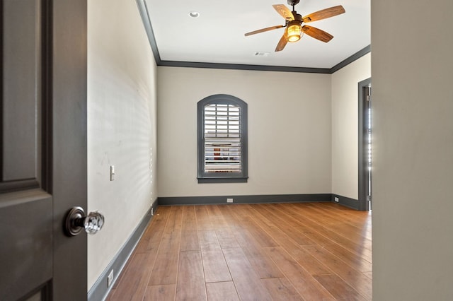 spare room featuring crown molding, ceiling fan, and light wood-type flooring