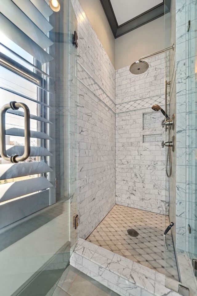 bathroom featuring ornamental molding and an enclosed shower