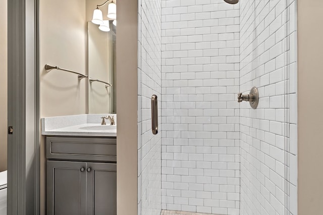 bathroom featuring vanity, a shower with shower door, and toilet