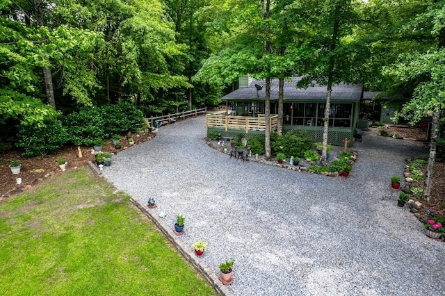 102 E Montego Ct, Milledgeville, GA 31061 - view of front of property with gravel driveway, a sunroom, and roof with shingles