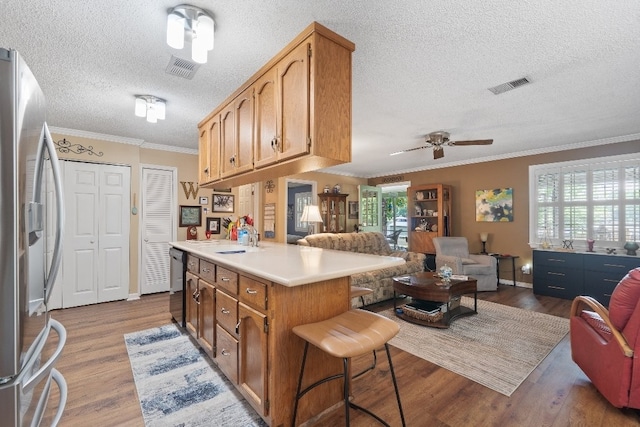102 E Montego Ct, Milledgeville, GA 31061 - kitchen with appliances with stainless steel finishes, a textured ceiling, open floor plan, dark wood-style floors, and light countertops