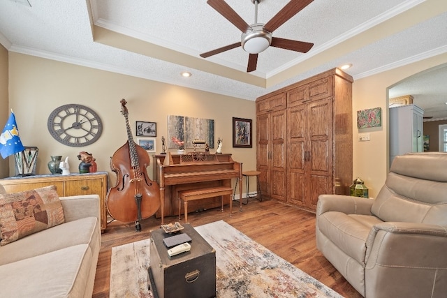 102 E Montego Ct, Milledgeville, GA 31061 - living area with a tray ceiling, a ceiling fan, crown molding, light wood-style floors, and a textured ceiling