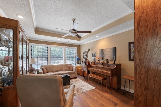 102 E Montego Ct, Milledgeville, GA 31061 - living area with a textured ceiling, a tray ceiling, ornamental molding, a ceiling fan, and wood finished floors
