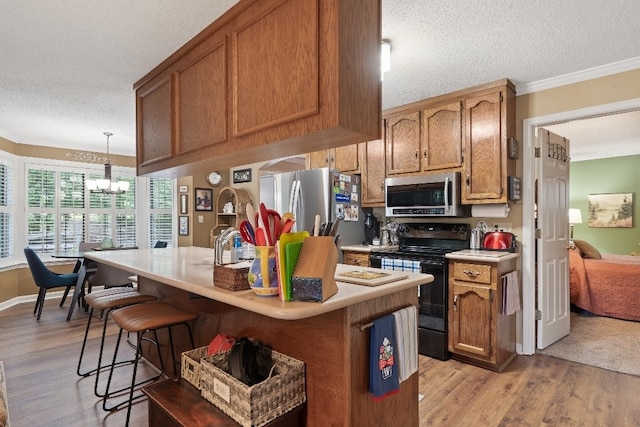 102 E Montego Ct, Milledgeville, GA 31061 - kitchen featuring appliances with stainless steel finishes, a textured ceiling, light wood-style flooring, crown molding, and light countertops