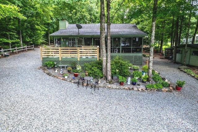 102 E Montego Ct, Milledgeville, GA 31061 - view of front of house featuring a chimney, driveway, a sunroom, and a wooden deck