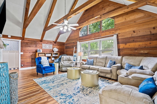 living room featuring light hardwood / wood-style flooring, ceiling fan, beam ceiling, high vaulted ceiling, and wood walls