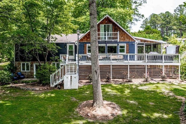 back of property with a sunroom, a yard, and a deck