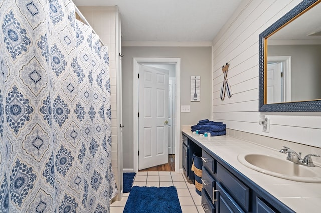 bathroom featuring vanity, wood walls, walk in shower, and tile patterned flooring