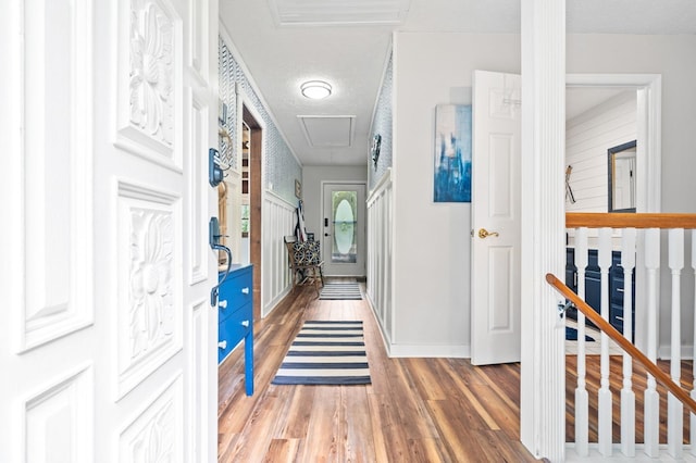 hallway with hardwood / wood-style floors and a textured ceiling