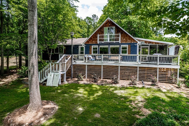 back of house featuring a deck, a sunroom, and a lawn