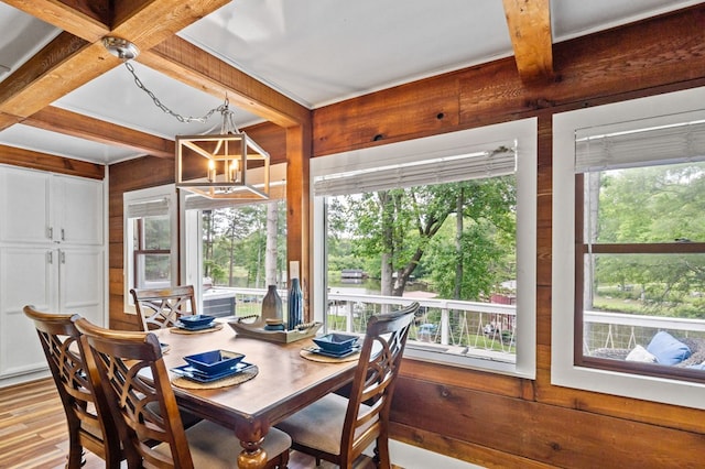 dining room featuring coffered ceiling, wooden walls, beam ceiling, and a notable chandelier