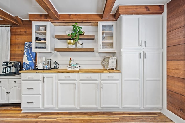 kitchen with wood walls, white cabinetry, beamed ceiling, and butcher block countertops