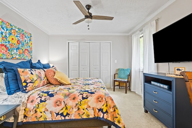 carpeted bedroom with a textured ceiling, a closet, ceiling fan, and ornamental molding