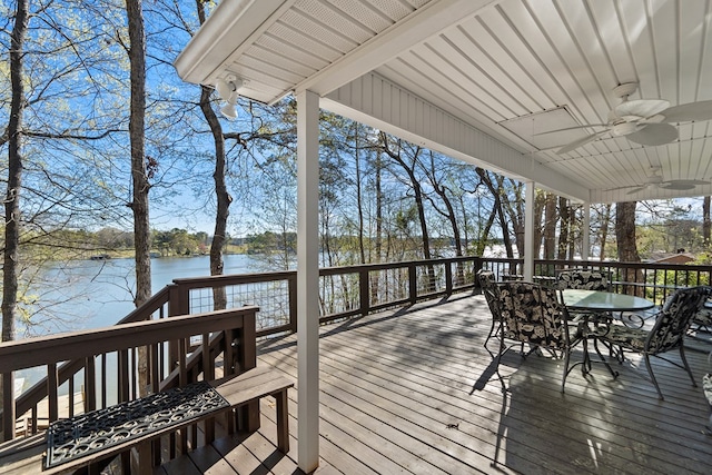 wooden terrace featuring a water view, ceiling fan, and outdoor dining space