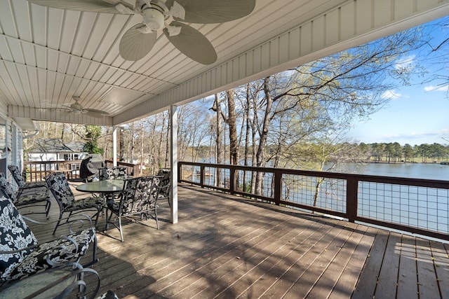 wooden deck featuring a water view, ceiling fan, and outdoor dining area