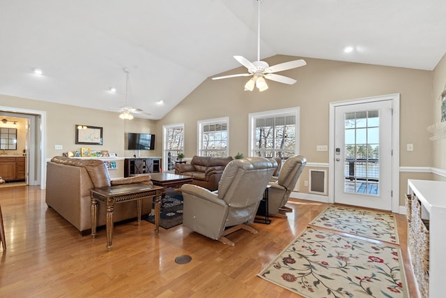 living area with light wood-type flooring, high vaulted ceiling, ceiling fan, and recessed lighting
