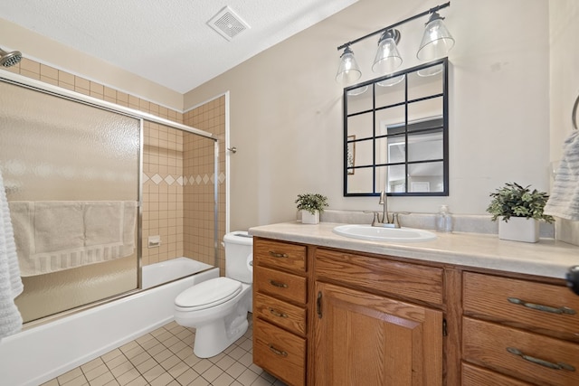 full bathroom with visible vents, bath / shower combo with glass door, toilet, vanity, and tile patterned floors