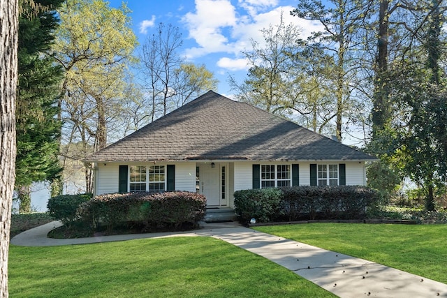 bungalow-style home with a shingled roof and a front yard