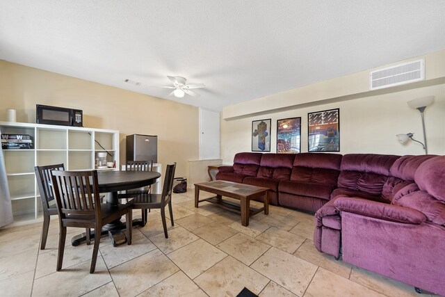 living room featuring visible vents and ceiling fan