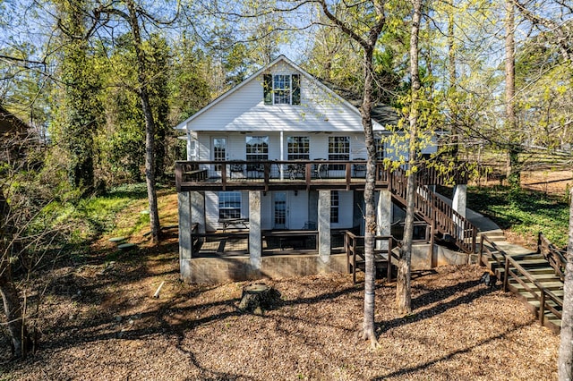 back of property featuring a deck and stairs