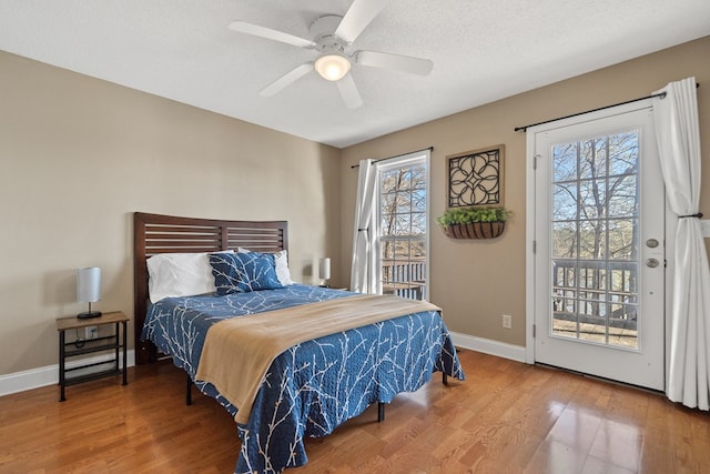 bedroom with access to exterior, a ceiling fan, wood finished floors, and baseboards
