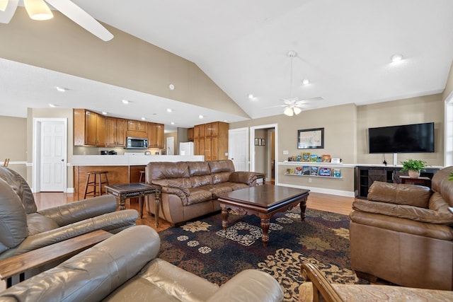 living room featuring baseboards, ceiling fan, recessed lighting, vaulted ceiling, and light wood-style flooring