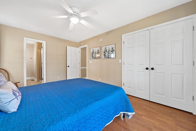 bedroom with wood finished floors, ceiling fan, a closet, and connected bathroom