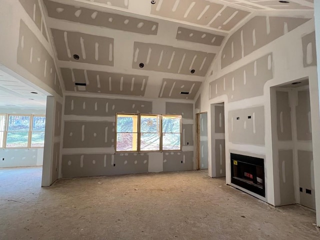 unfurnished living room with plenty of natural light, a fireplace, and high vaulted ceiling