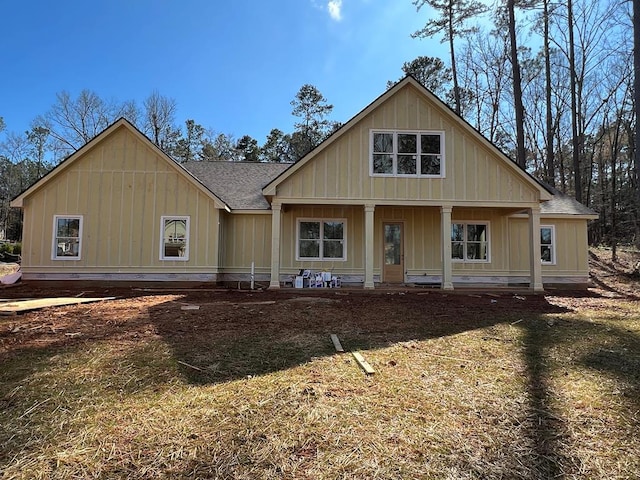 view of front facade featuring covered porch, a shingled roof, and board and batten siding