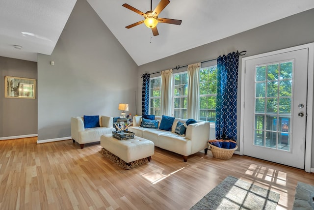 living room with high vaulted ceiling, plenty of natural light, light hardwood / wood-style floors, and ceiling fan