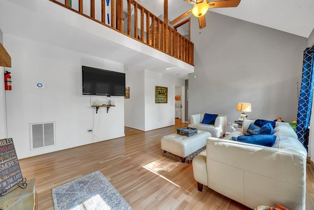 living room featuring ceiling fan, hardwood / wood-style floors, and high vaulted ceiling