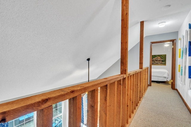 hallway featuring carpet and vaulted ceiling