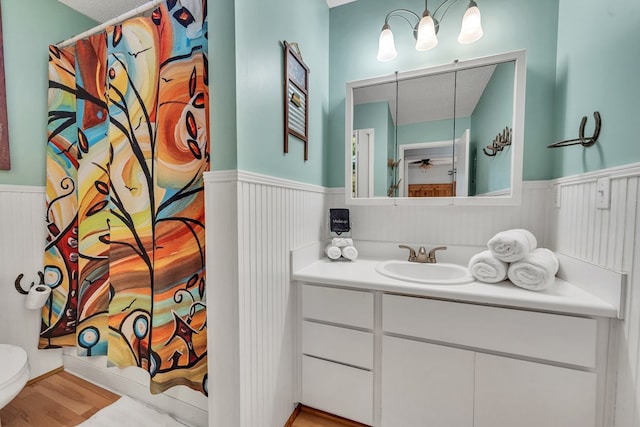 bathroom featuring wood-type flooring, vanity, a textured ceiling, and toilet