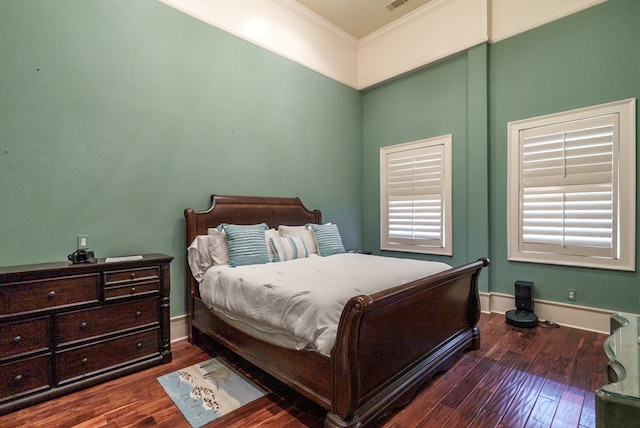 bedroom with dark hardwood / wood-style flooring and crown molding