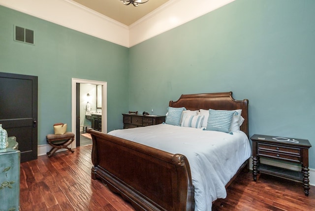 bedroom with dark hardwood / wood-style floors, ornamental molding, and ensuite bath