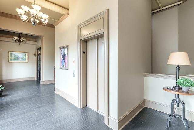 corridor featuring elevator, crown molding, and a notable chandelier