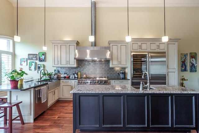 kitchen with pendant lighting, stainless steel appliances, dark stone counters, and sink