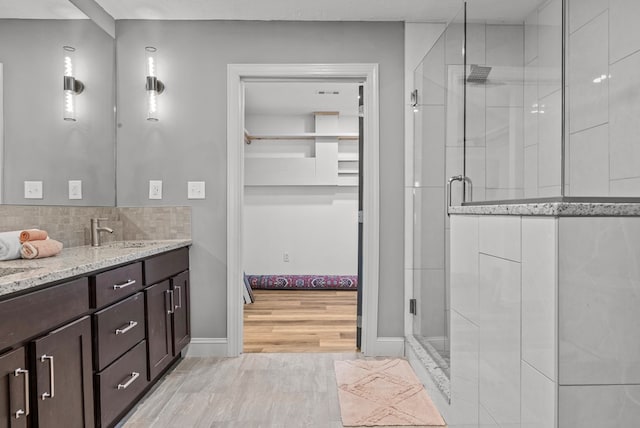 bathroom with vanity, an enclosed shower, and hardwood / wood-style flooring