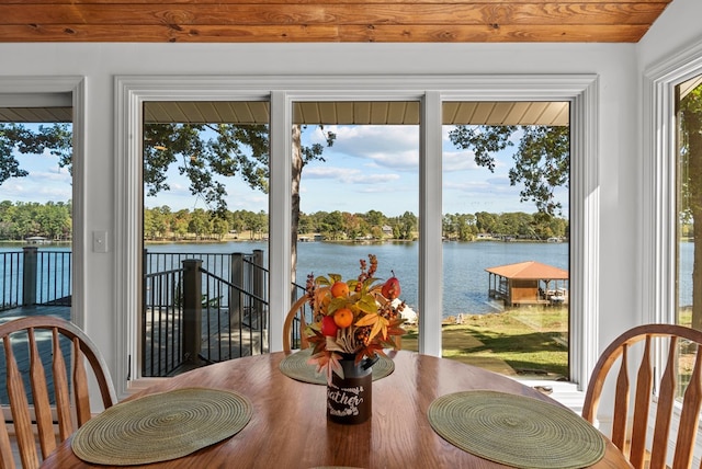 dining space with a water view and lofted ceiling