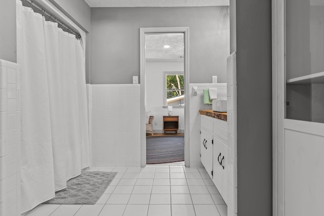 bathroom featuring tile patterned flooring, vanity, and a textured ceiling