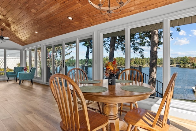 sunroom / solarium with a healthy amount of sunlight, a water view, wooden ceiling, and ceiling fan with notable chandelier